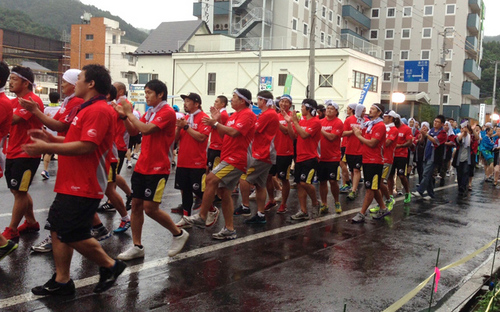 釜石よいさ祭りで、雨天の中、行進する釜石シーウェイブスの選手たち