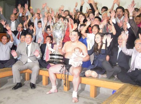 ２場所連続優勝を飾った日馬富士が優勝杯を手にして朝青龍（写真左）や家族とともに喜びを分かち合う。