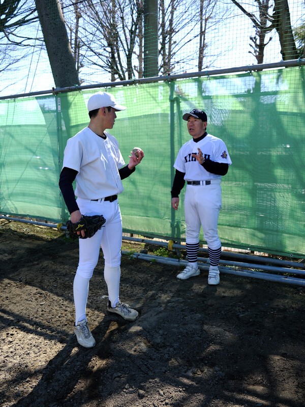 投手の後ろに立ちフォーム指導をする松本 photo by Sportiva