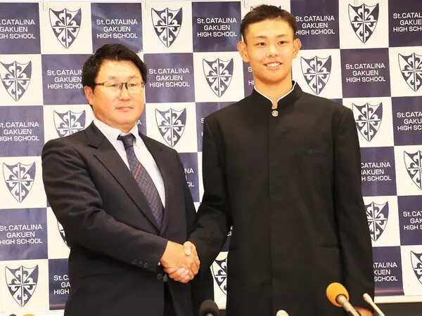 今秋のドラフトで中日から６位指名された有馬恵叶（写真右）と聖カタリナ・浮田宏行監督　photo by Sugino Ichiro
