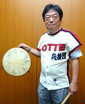 応援団員当時のユニフォームを着た横山氏。太鼓には選手のサインが