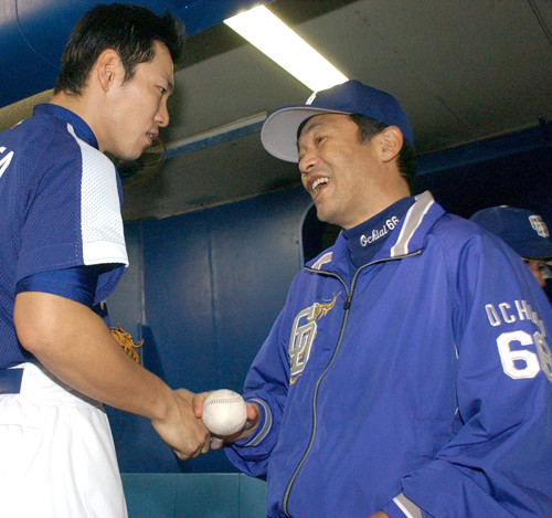 2004年シーズン最終戦のウイニングボールを落合博満監督（右）に渡す井端（左）