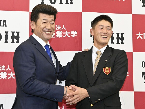 DeNAの三浦大輔監督（左）と握手する、１位指名を受けた大阪桐蔭高の捕手・松尾汐恩