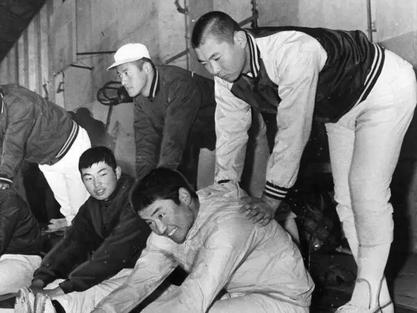 柔軟体操で佃正樹（写真手前下）の背中を押す江川卓　photo by Sankei Visual