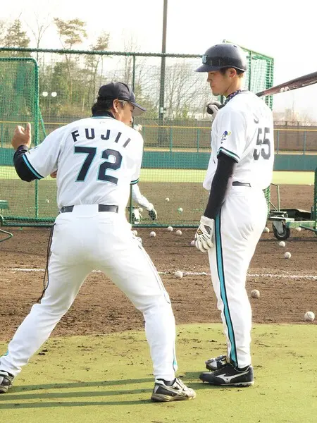 藤井康雄コーチ（当時／写真左）のアドバイスを聞くＴ−岡田　photo by Tanigami Shiro