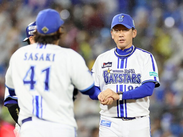 日本シリーズ第２戦、２番手の佐々木千隼にボールを渡すDeNA三浦大輔監督 photo by Sankei Visual