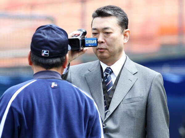 引退後、解説者となった江川卓（写真右）から取材を受けるコーチ時代の高木豊　photo by Sankei Visual