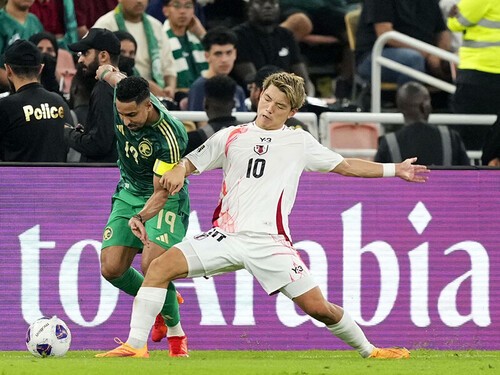 サウジアラビアのアタッカーと激しく競り合う堂安律 photo by Kyodo news