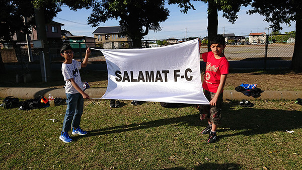 サラマットFCの旗を掲げる子どもたち　photo by Kimura Yukihiko