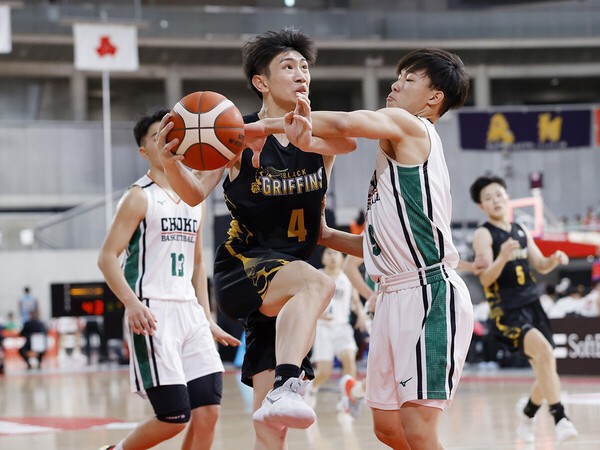 相手選手と競り合いながらシュートを放つ和歌山南陵・二宮有志（写真中央）　photo by Kyodo News