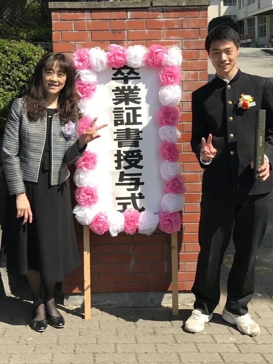 母親と記念撮影した中学での卒業式。よく見るとシューズはボロボロ