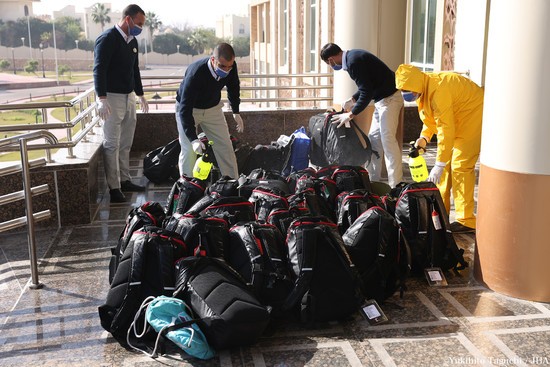 ホテルの玄関で、選手の荷物を消毒する係員
