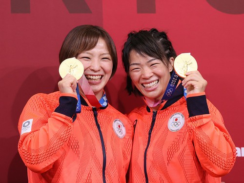 姉妹で金メダルを掲げる、姉の川合梨紗子（右）と妹の友香子（左）