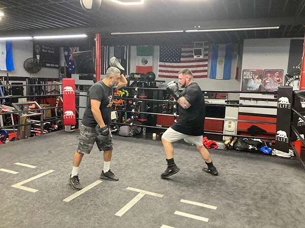 一度は指導をやめた、アンディ・ルイス・ジュニア（右）のミット打ちを行なうロブレス