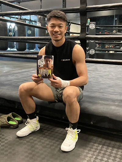 発売早々に重版が決まった自身の書籍を手に笑顔