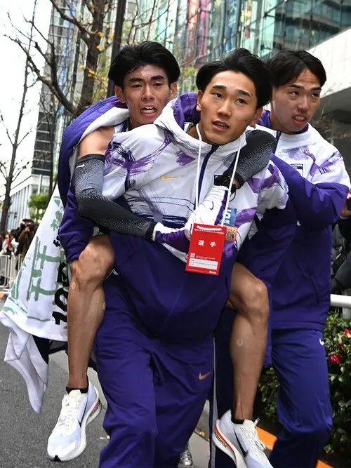 駒大の復路優勝のゴールテープを切った小山翔也を抱え、好走を労う主将の篠原　photo by Kishimoto Tsutomu