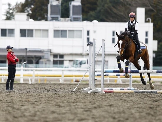 騎乗訓練での障害飛越。傍らで教官が見守る