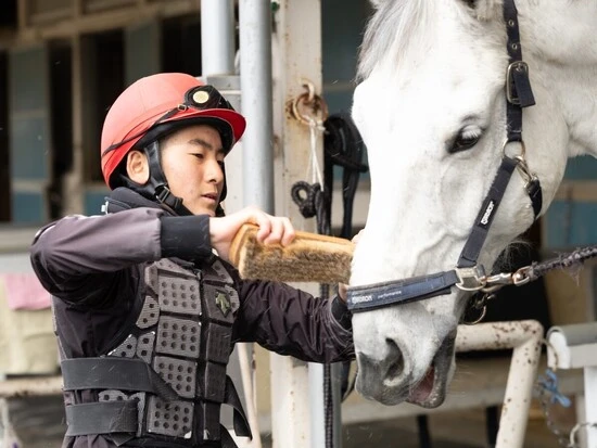 厩舎作業をする生徒。馬の体を洗ったり蹄の手入れをしたりして、馬ともコミュニケーションをとる　photo by Hisaya Hirose