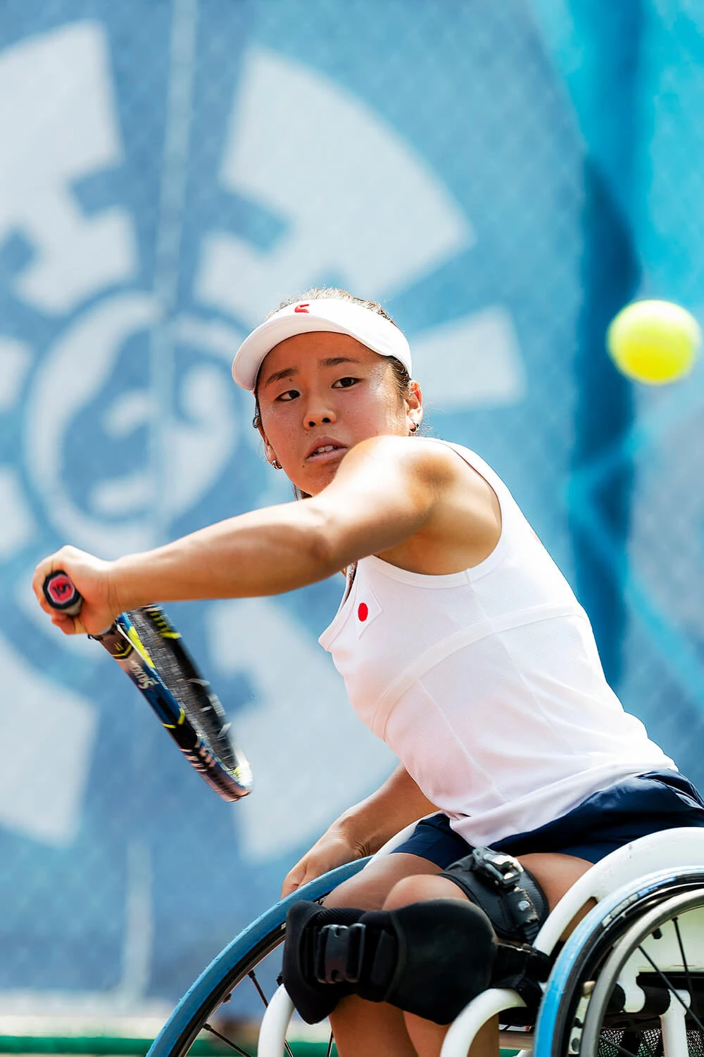 写真：飛んできたボールをボレーで打ち返そうと、ラケットを持った左手を後ろに引いて待ち構える車いすテニス上地結衣選手