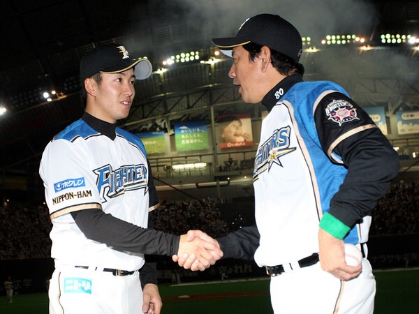 2012年の開幕戦をプロ初の完投勝利で飾った斎藤佑樹（写真左）を称える栗山英樹監督
