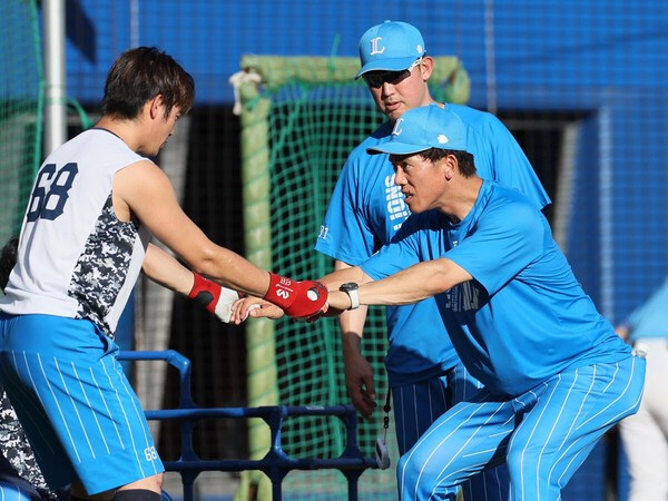 シーズン中の試合前、岸潤一郎（左）に指導する西武・松井稼頭央監督