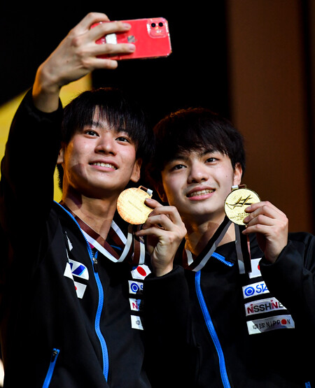 アジア選手権の男子ダブルスで優勝し、記念撮影する明治大の戸上（左）と宇田
